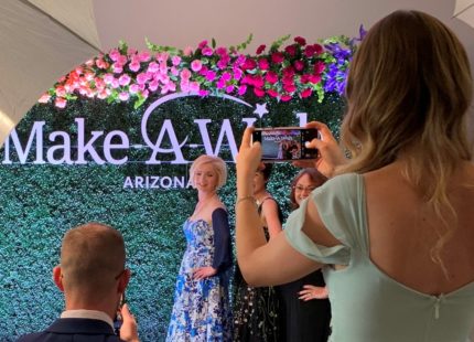 make-a-wish-hedge-photo-op-wall-over-shoulder-of-volunteers-CROPPED-4x6-ratio